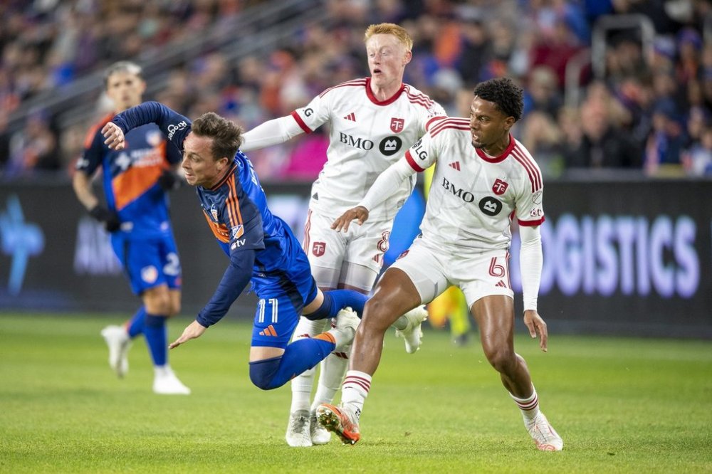 Toronto FC, in search of its first win under coach Robin Fraser after an 0-2-1 start on the road, trains at BMO Field on Friday for the first time this year ahead of Saturday's home opener against Chicago. FC Cincinnati forward Corey Baird (11) is tripped by Toronto FC midfielders Kosi Thompson (6) and Matty Longstaff (8) during an MLS soccer match, Saturday, March 8, 2025, in Cincinnati. THE CANADIAN PRESS/AP/Tanner Pearson