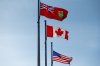 The Ontario, Canadian and U.S. flags are seen at the Canada Border Services Agency Lansdowne port of entry in Lansdowne, Ont., on Wednesday, Feb. 12, 2025. THE CANADIAN PRESS/Spencer Colby