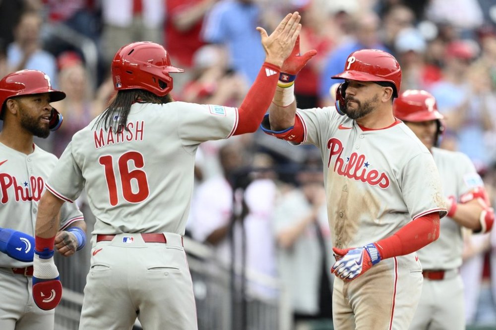Philadelphia Phillies' Kyle Schwarber, right, celebrates his three-run home run with Brandon Marsh (16) during the sixth inning of a baseball game against the Washington Nationals, Saturday, March 29, 2025, in Washington. (AP Photo/Nick Wass)
