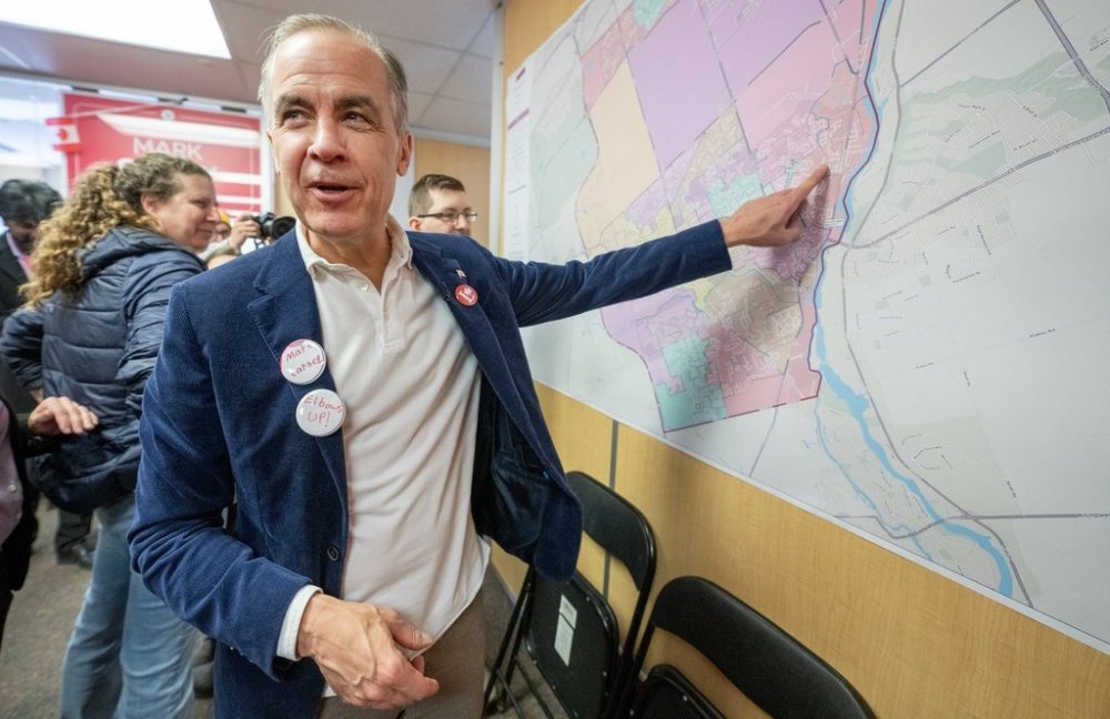 Liberal Leader Mark Carney looks over a map of his riding at his campaign office in Nepean, ON on Saturday March 29, 2025. THE CANADIAN PRESS/Frank Gunn