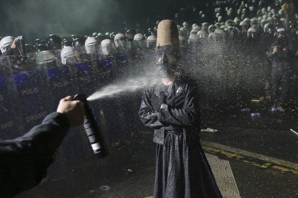 Riot police officers use pepper spray to clear a protester during a protest after Istanbul's Mayor Ekrem Imamoglu was arrested and sent to prison, in Istanbul, Turkey, Sunday, March 23, 2025. (AP Photo/Huseyin Aldemir)