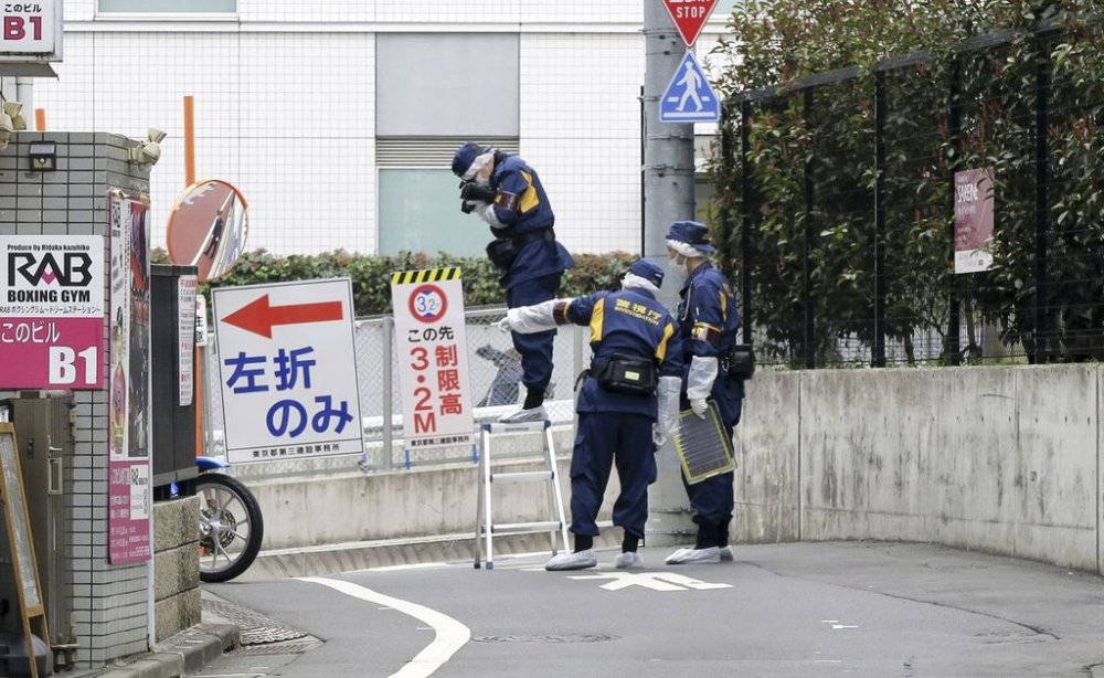 Japanese police investigators work near the scene of a stabbing of a woman in the Shinjuku district of Tokyo, Tuesday, March 11, 2025. (Kyodo News via AP)