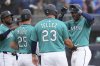 Seattle Mariners' Julio Rodríguez, right, celebrates his grand slam against the Kansas City Royals with Mariners' Rowdy Tellez (23), Dylan Moore (25) and Victor Robles, left, during the second inning of a spring training baseball game Wednesday, March 12, 2025, in Peoria, Ariz. (AP Photo/Ross D. Franklin)