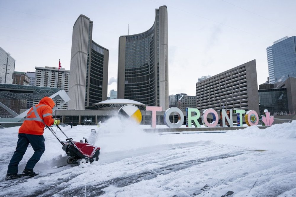 A worker uses a snowblower to clear snow from Nathan Phillips Square at city hall following a heavy snowfall in Toronto, on Thursday, February 13, 2025. THE CANADIAN PRESS/Arlyn McAdorey