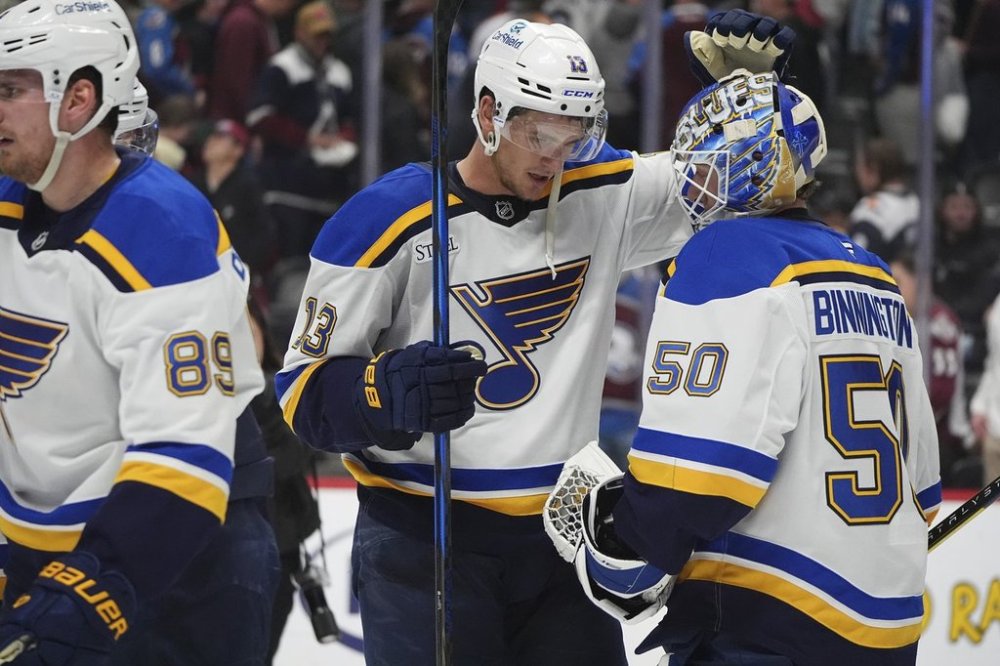 St. Louis Blues right wing Alexey Toropchenko, left, congratulates goaltender Jordan Binnington after an NHL hockey game against the Colorado Avalanche Saturday, March 29, 2025, in Denver. (AP Photo/David Zalubowski)