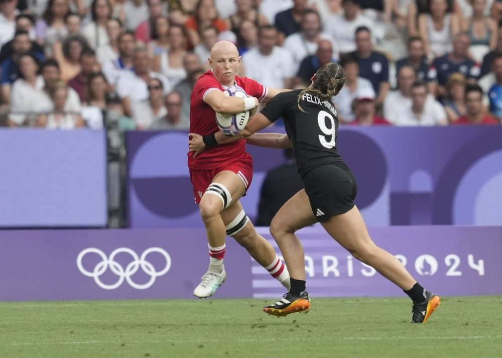 Canada back Olivia Apps (2) runs by New Zealand back Jazmin Felix-Hotham (9) during the women's rugby sevens gold medal match at the Summer Olympics in Paris on July 30, 2024. THE CANADIAN PRESS/Adrian Wyld