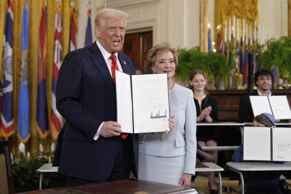 President Donald Trump holds up a signed executive order alongside Secretary of Education Linda McMahon in the East Room of the White House in Washington, Thursday, March 20, 2025. (AP Photo/Ben Curtis)