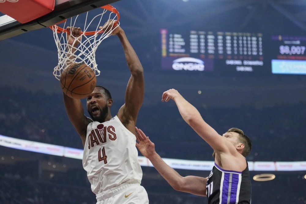 Cleveland Cavaliers forward Evan Mobley (4) dunks in front of Sacramento Kings forward Domantas Sabonis, right, in the first half of an NBA basketball game Sunday, April 6, 2025, in Cleveland. (AP Photo/Sue Ogrocki)