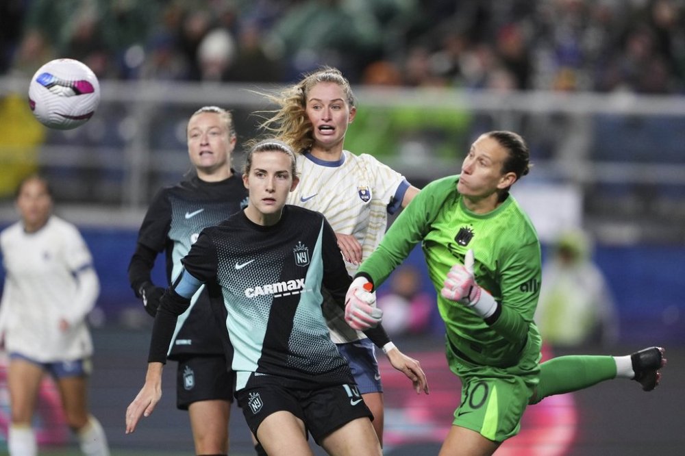 Seattle Reign FC forward Jordyn Huitema, back center, looks on with NJ/NY Gotham FC defender Tierna Davidson, left, as goalkeeper Ann-Katrin Berger (30) punches the ball away during the second half of an NWSL soccer match Saturday, March 15, 2025, in Seattle. (AP Photo/Lindsey Wasson)