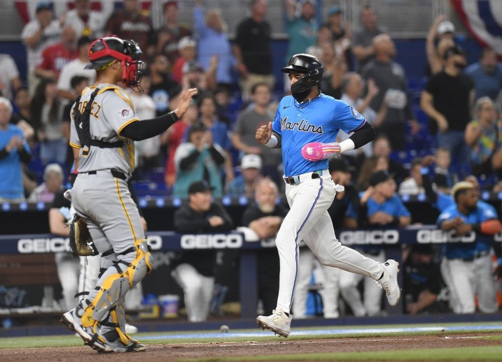 Miami Marlins' Derek Hill, right, scores on a double by teammate Nick Fortes during the second inning of a baseball game against the Pittsburgh Pirates, Sunday, March 30, 2025, in Miami. (AP Photo/Michael Laughlin)