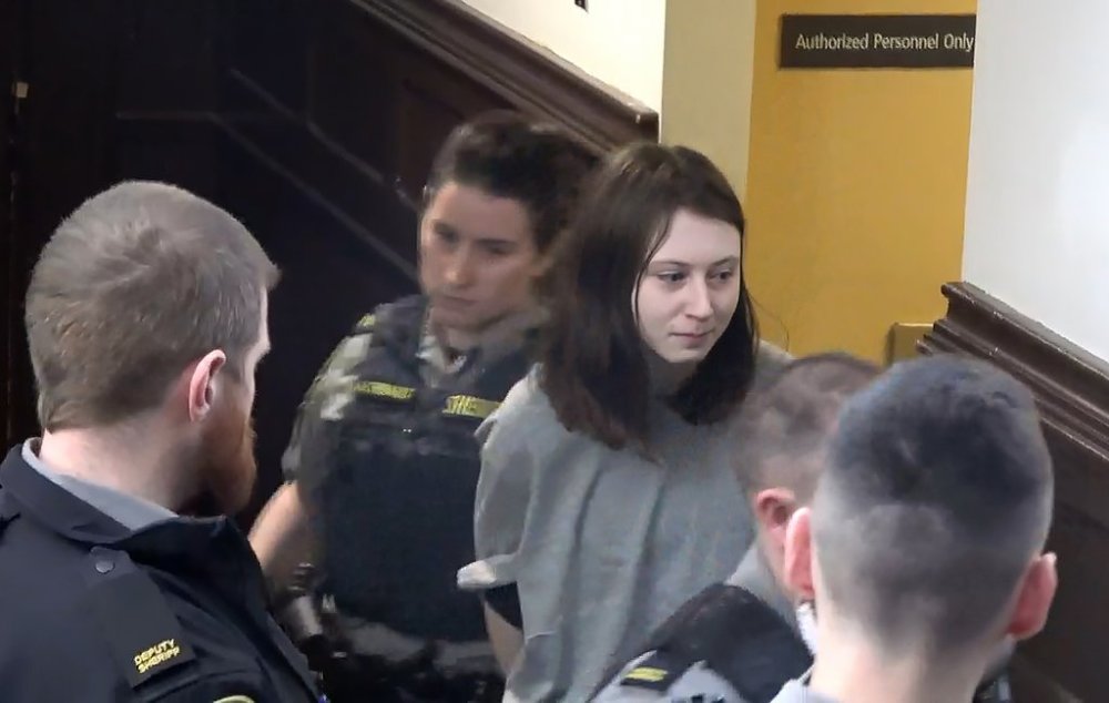 Elliott Chorny, centre right, is escorted into a Halifax courtroom as shown in this still image taken from a video recorded on Monday. Chorny, 19, is facing an attempted murder charge in the Feb. 23 stabbing of the young child, who police say was rushed to hospital with life-threatening injuries, but was later reported to be in stable condition. THE CANADIAN PRESS/Michael MacDonald