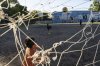 Alexis Lara strikes a soccer ball to his friend Yamil Manrique tending the goal line, backdropped by a mural dedicated to soccer legend Diego Maradona, in Buenos Aires, Argentina, Tuesday, March 25, 2025. (AP Photo/Rodrigo Abd)