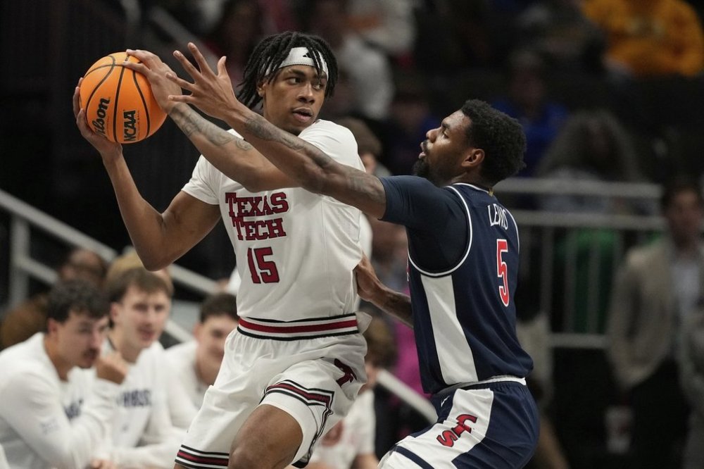 Texas Tech's JT Toppin (15) looks to pass as Arizona's KJ Lewis (5) defends during the first half of an NCAA college basketball game in the semifinal round of the Big 12 Conference tournament, Friday, March 14, 2025, in Kansas City, Mo. (AP Photo/Charlie Riedel)