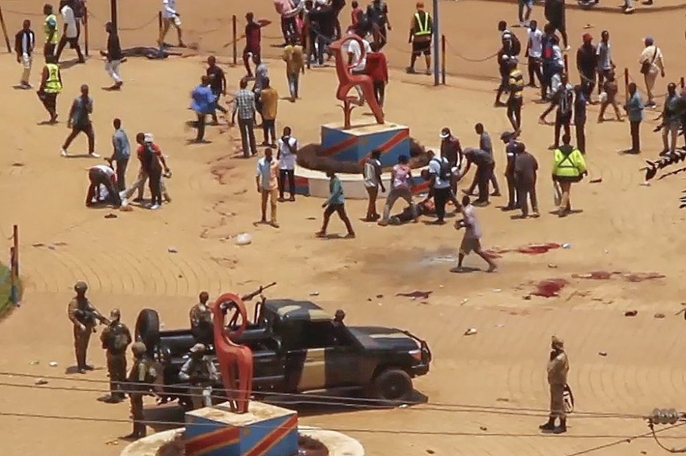 In this video frame grab, people assist victims after two explosions hit a meeting of M23 rebel group leaders and residents in Bukavu, eastern Congo, Thursday, Feb. 27, 2025. (AP Photo/Janvier Barhahiga)