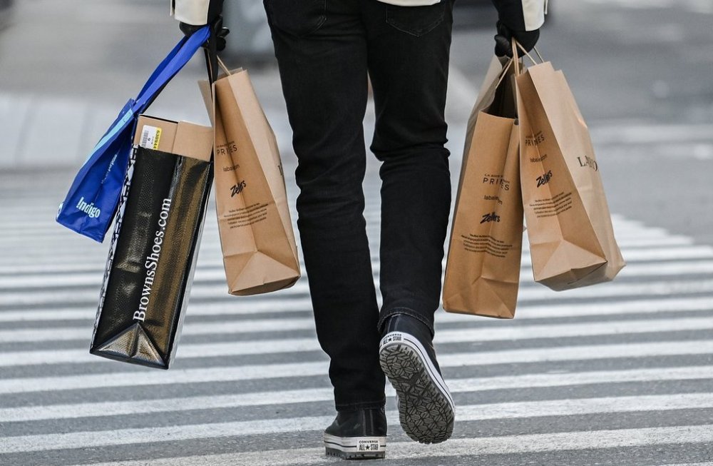 A person carries shopping bags along a street in Montreal, Saturday, December 14, 2024. February's inflation release from Statistics Canada revealed the impact of an unwinding of the two-month federal sales tax break. THE CANADIAN PRESS/Graham Hughes