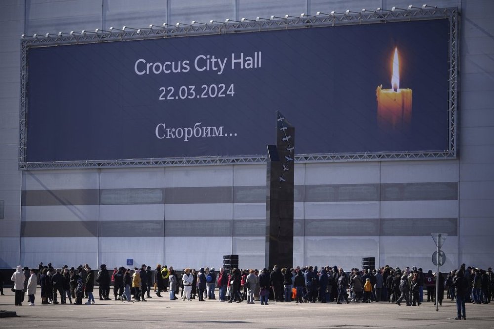 People gather at the newly opened memorial at the Crocus City Hall on the western outskirts of Moscow, Russia, Saturday, March 22, 2025, one year on from the concert hall attack that killed 145 people. (AP Photo/Pavel Bednyakov)