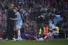 Manchester City's head coach Pep Guardiola hugs Phil Foden as he is substituted during the English Premier League soccer match between Manchester City and Manchester United in Manchester, England, Sunday, April 6, 2025. (AP Photo/Dave Thompson)