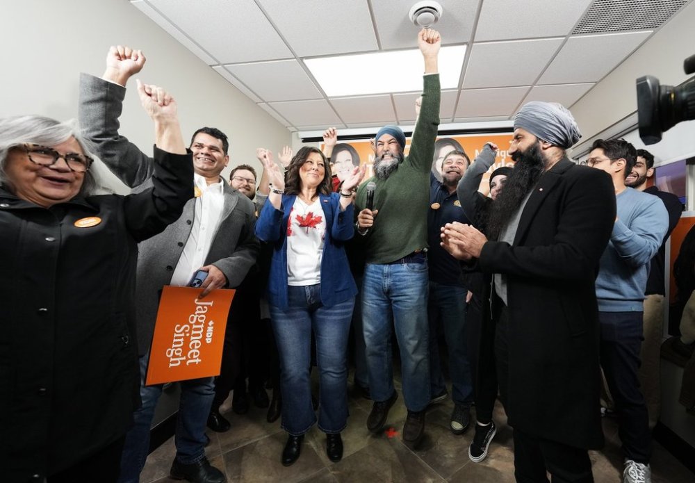 NDP Leader Jagmeet Singh, right centre, jumps next to NDP candidate Monique Taylor, left centre, as he attends an event during a federal election campaign stop in Hamilton on Tuesday, March 25, 2025. THE CANADIAN PRESS/Nathan Denette