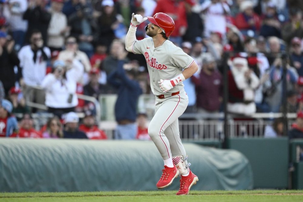 Philadelphia Phillies' Bryce Harper celebrates as he rounds the bases on his home run in the seventh inning of an opening-day baseball game against the Washington Nationals, Thursday, March 27, 2025, in Washington. (AP Photo/Nick Wass)