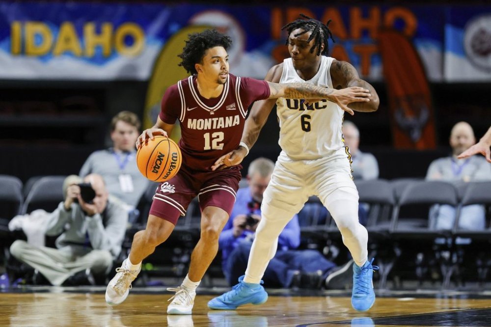 Montana guard Brandon Whitney (12) works the ball around the defense of Northern Colorado guard Langston Reynolds (6) during an NCAA college basketball game in the championship of the Big Sky tournament, Wednesday, March 12, 2025, in Boise, Idaho. (AP Photo/Steve Conner)