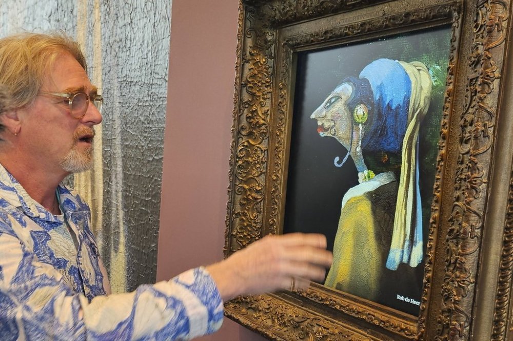 Rob de Heer talks next to his artwork, one of 60 pieces exhibited and inspired by the famous