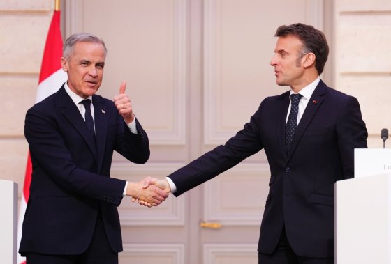 Prime Minister Mark Carney, left, gives a thumbs up as he shakes hands with President of France Emmanuel Macron at the Palais de l'Elysee in Paris, France. (Sean Kilpatrick / The Canadian Press)