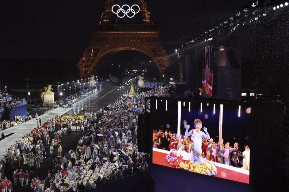FILE - Delegations arrive at the Trocadero as spectators watch French singer Philippe Katerine performing on a giant screen, in Paris, during the opening ceremony of the 2024 Summer Olympics, July 26, 2024 in Paris. (Ludovic Marin/Pool Photo via AP, File)