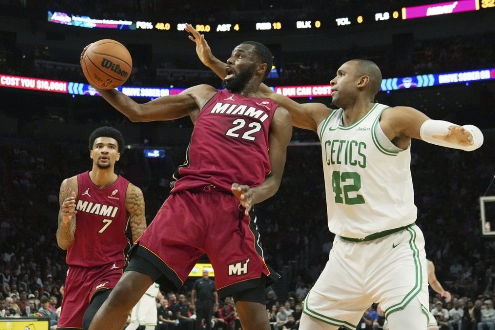 Miami Heat forward Andrew Wiggins (22) and Boston Celtics center Al Horford (42) go after a rebound during the first half of an NBA basketball game, Friday, March 14, 2025, in Miami. (AP Photo/Marta Lavandier)