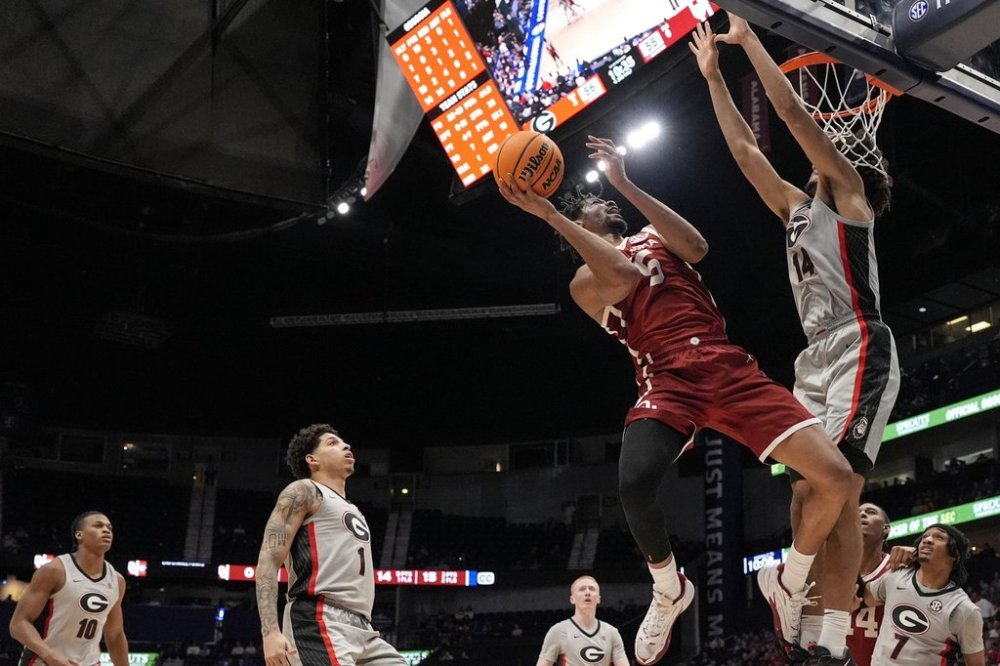 Oklahoma guard Duke Miles (15) shoots against Georgia forward Asa Newell (14) during the second half of an NCAA college basketball game at the Southeastern Conference tournament, Wednesday, March 12, 2025, in Nashville, Tenn. (AP Photo/George Walker IV)