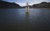 The belfry an 11th century Romanesque church emerges from the Sau reservoir, about 100 km (62 miles) north of Barcelona, in Vilanova de Sau, Spain, on Monday, March 24, 2025. (AP Photo/Emilio Morenatti)