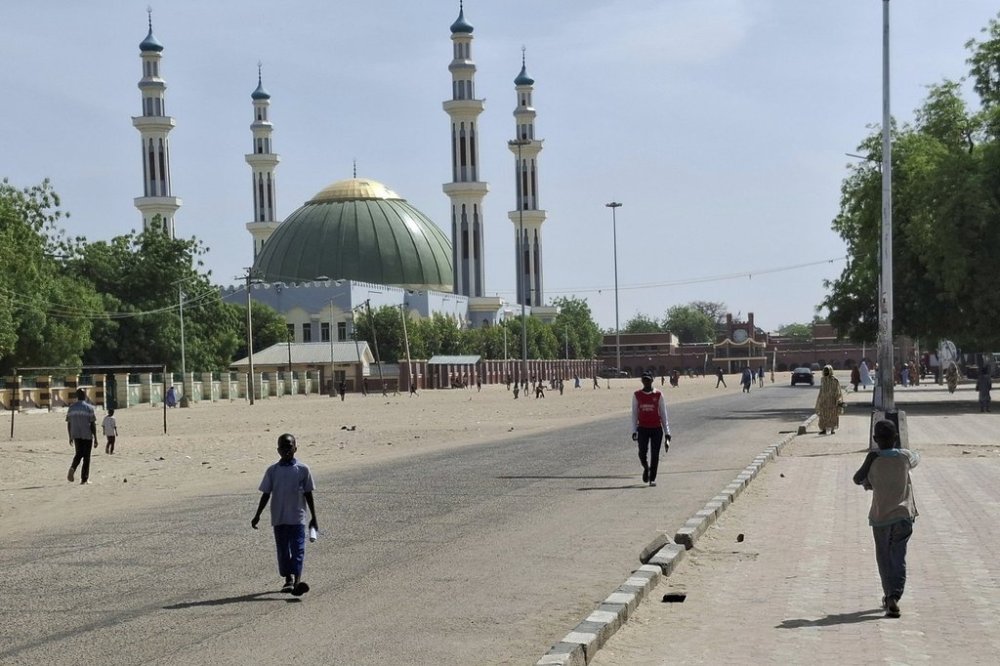 People walk past a mosque in Maiduguri, Nigeria, Friday, March 14, 2025. (AP Photo/Joshua Olatunji)