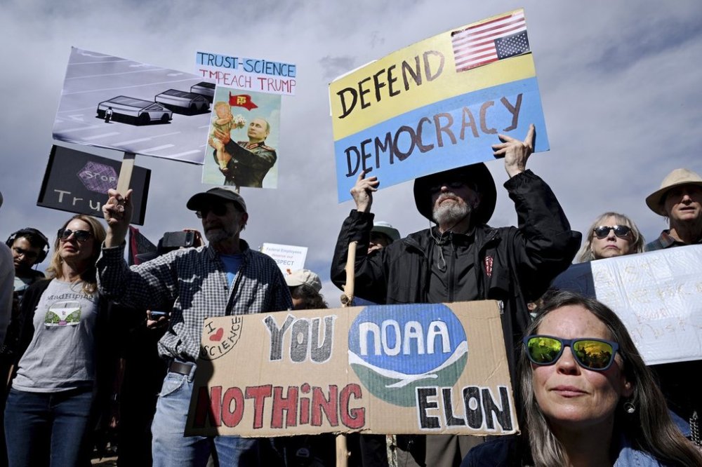Susie House, front, and David Hill hold up signs as they join hundreds of others during a large rally and protest outside the National Oceanic and Atmospheric Administration campus Monday, March 3, 2025, in Boulder, Colo. (Helen H. Richardson/The Denver Post via AP)