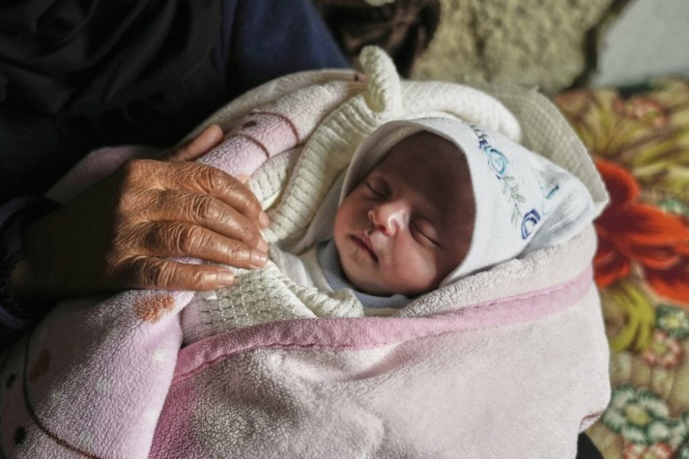 Ella Osama Abu Dagga, 25 days old, is held by her great-aunt Suad Abu Dagga after she was pulled from the rubble earlier following an Israeli army airstrike that killed her parents and brother in Khan Younis, southern Gaza Strip, Thursday, March 20, 2025. (AP Photo/Abdel Kareem Hana )