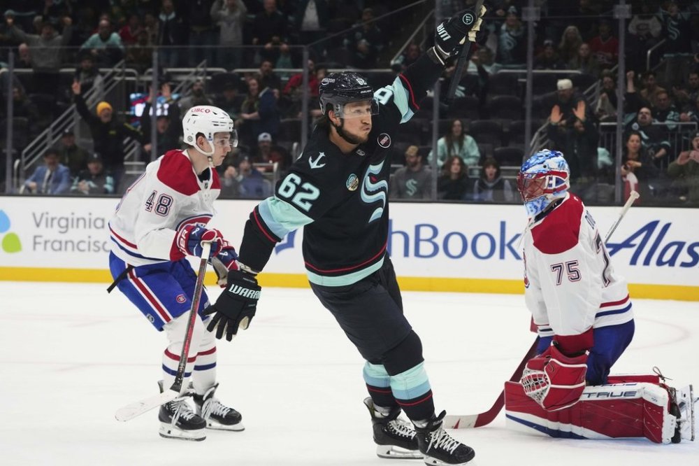 Seattle Kraken defenseman Brandon Montour (62) reacts to scoring to win 5-4 in overtime as Montreal Canadiens defenseman Lane Hutson (48) and goaltender Jakub Dobes (75) react in an NHL hockey game Wednesday, March 12, 2025, in Seattle. (AP Photo/Lindsey Wasson)