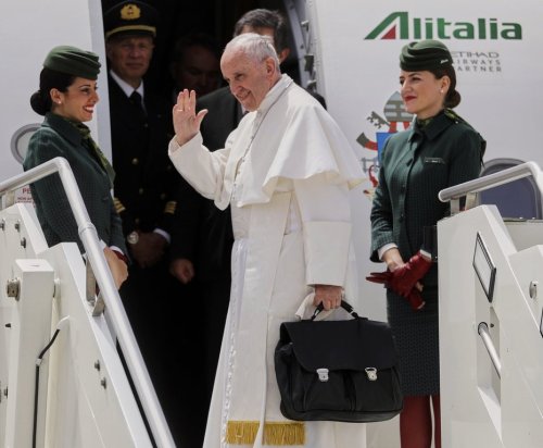 FILE - In this May 12, 2017 file photo, Pope Francis holds his bag and waves as he embarks his flight to Monte Real, Portugal, from Rome's International airport of Leonardo Da Vinci, in Fiumicino, Italy. (AP Photo/Gregorio Borgia, file)