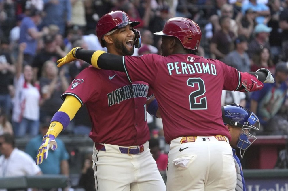 Arizona Diamondbacks' Lourdes Gurriel Jr., left, celebrates with Geraldo Perdomo (2) after hitting a two-run home run against the Chicago Cubs in the eighth inning during a baseball game, Sunday, March 30, 2025, in Phoenix. (AP Photo/Rick Scuteri)