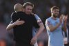 Manchester City's Kevin De Bruyne, center, celebrates with Manchester City's head coach Pep Guardiola, left, at the end of the English FA Cup quarterfinal soccer match between Bournemouth and Manchester City at the Vitality stadium in Bournemouth, England, Sunday, March 30, 2025. (AP Photo/Ian Walton)