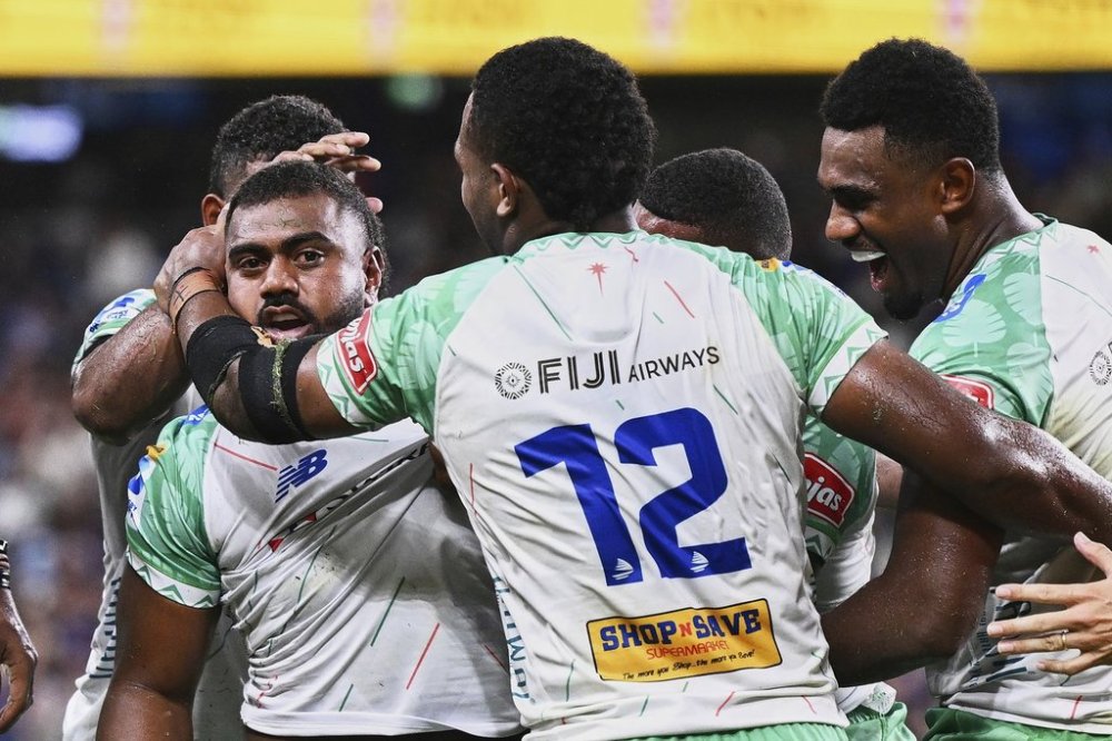 Fijian Drua player Mesulame Dolokoto, left, is congratulated by teammates after scoring a try during the Super Rugby Pacific Round 3 match between the NSW Waratahs and Fijian Drua at Allianz Stadium in Sydney, on Feb. 28, 2025. (Dan Himbrechts/AAP Image via AP)