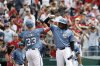 Washington Nationals' Nathaniel Lowe (33) is greeted by Josh Bell, right, after hitting a two-un home run off Philadelphia Phillies pitcher Aaron Nola during the sixth inning of a baseball game in Washington, Sunday, March 30, 2025. (AP Photo/Terrance Williams)