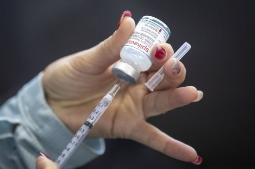 A person draws out vaccine during a drive-thru COVID-19 immunization clinic at St. Lawrence College in Kingston, Ont., on Sunday Jan. 2, 2022. THE CANADIAN PRESS/Lars Hagberg