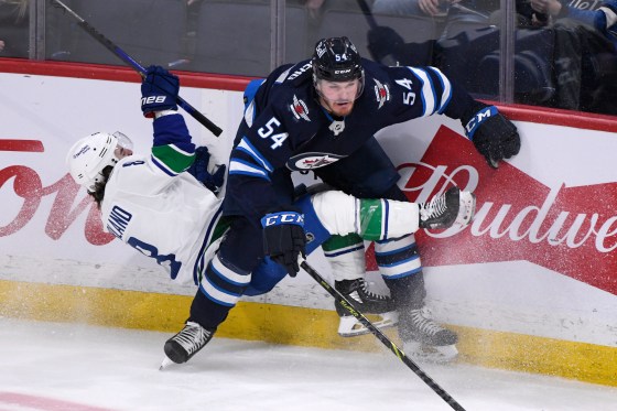 Vancouver Canucks' Conor Garland (8) is checked by Winnipeg Jets' Dylan Samberg (54) during the Jan. 8 game. (Fred Greenslade/The Canadian Press files)