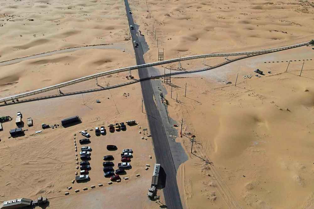 A 42-mile conveyor belt by Atlas Energy cuts through a sand dune as it carries sand needed for hydraulic fracturing Wednesday, Feb. 26, 2025, in Kermit, Texas. (AP Photo/Julio Cortez)