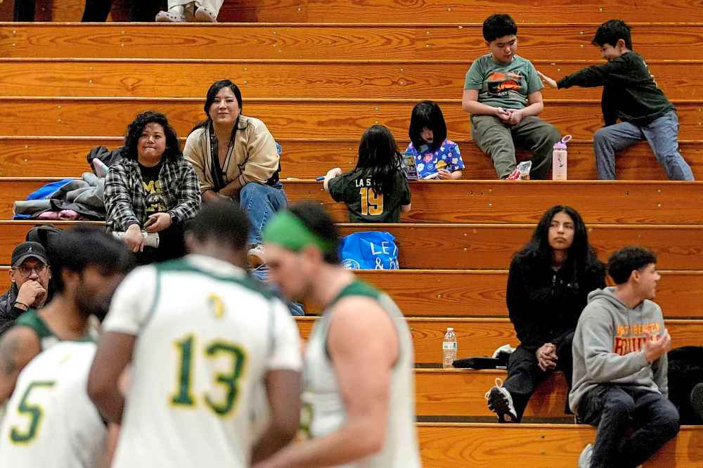Fans, including Damon LaSalle's wife, Christina, second from left, and kids watch the New Jersey City University men's volleyball team play against University of Mount Saint Vincent, Wednesday, March 5, 2025, at New Jersey City University in Jersey City, N.J. (AP Photo/Julia Demaree Nikhinson)