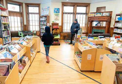 A young girl walks over the Canada-USA international border line into Canada from inside the Haskell Free Library and Opera House in Derby Line, Vermont on Friday, March 21, 2025. The town of Stanstead, Que., says U.S. authorities have unilaterally decided to 