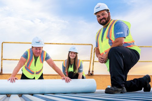 Employees at Transcona Roofing work on a rooftop during installation.