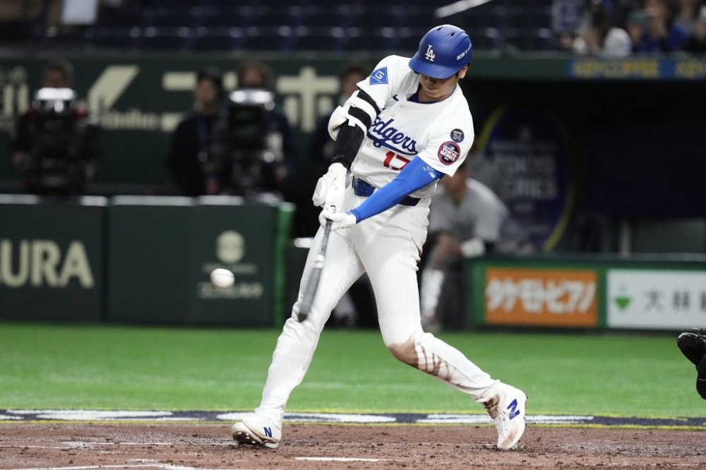 Los Angeles Dodgers' Shohei Ohtani connects for a two-run home run in the third inning of a spring training baseball game against the Yomiuri Giants in Tokyo, Japan, Saturday, March 15, 2025. (AP Photo/Eugene Hoshiko)