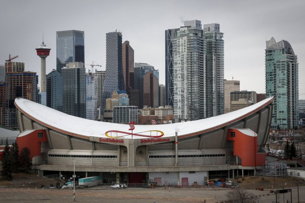The city skyline is seen behind the Saddledome, home of the Calgary Flames, in Calgary, Alta., Thursday, March 12, 2020. THE CANADIAN PRESS/Jeff McIntosh