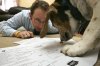 FILE - Bryan Zygmont works with his dog, Romey, to fill out the 2009 NCAA Tournament brackets at his Dubuque, Iowa, home Tuesday, March 17, 2009. (Jeremy Portje/Telegraph Herald via AP, File)