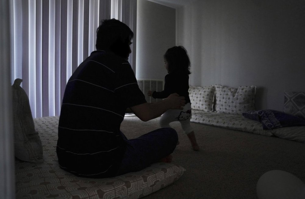Rahmani, an Afghan refugee and father of two, plays with his daughter at the apartment where they were resettled by the Lutheran Social Services National Capital Area organization in Laurel, Md., Monday, March 3, 2025. He and his family are among thousands of newly arrived refugees who lost financial assistance when President Donald Trump cut off funding for the federal refugee program in January. (AP Photo/Jessie Wardarski)