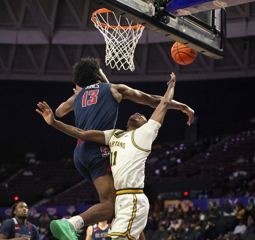 South Carolina State forward Drayton Jones (13) blocks a shot from Norfolk State guard Jaylani Darden (11) during the first half of an NCAA college basketball game in the championship of the Mid-Eastern Athletic Conference Tournament, Saturday, March 15, 2025, in Norfolk, Va. (AP Photo/Mike Caudill)